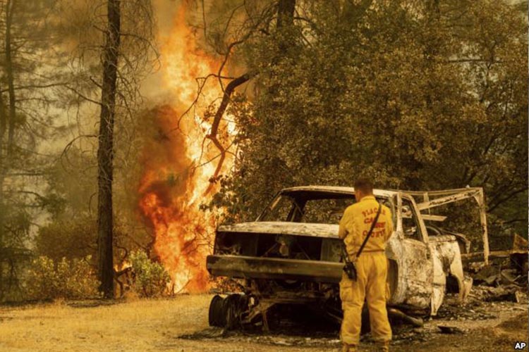 Un bombero observa las llamas de un incendio en Redding, California, el 28 de julio de 2018.