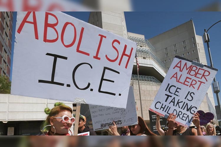 Manifestantes portan carteles durante un acto frente a la oficina del Servicio de Inmigración y Aduanas, ICE, en Los Ángeles, California, el lunes, 2 de julio de 2018.