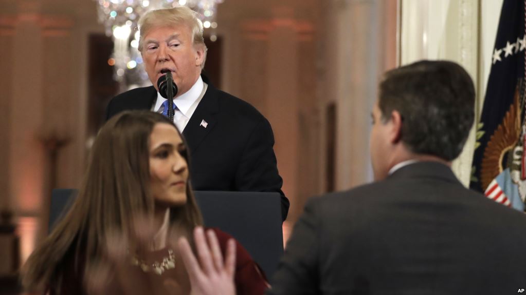 Una asistente de la Casa Blanca toma el micrófono del reportero Jim Acosta de CNN, en una conferencia de prensa en Washington.