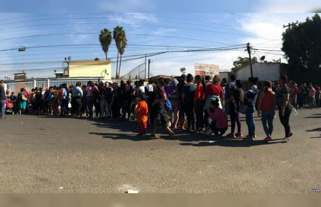 Miembros de la caravana, hacen fila para recibir comida, en Tijuana. Celia Mendoza - VOA