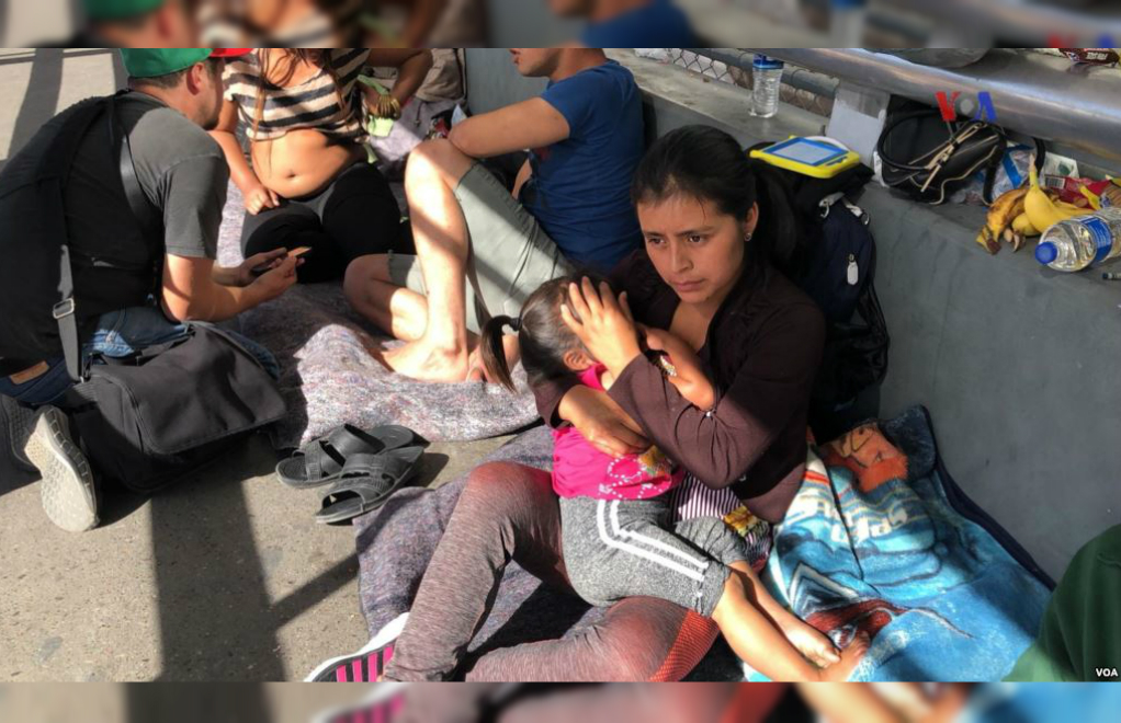 Migrantes de Guatemala, Cuba, Honduras y El Salvador hacen fila en el Puente Internacional de Santa Fe, El Paso en Texas, para solicitar asilo político en Estados Unidos.