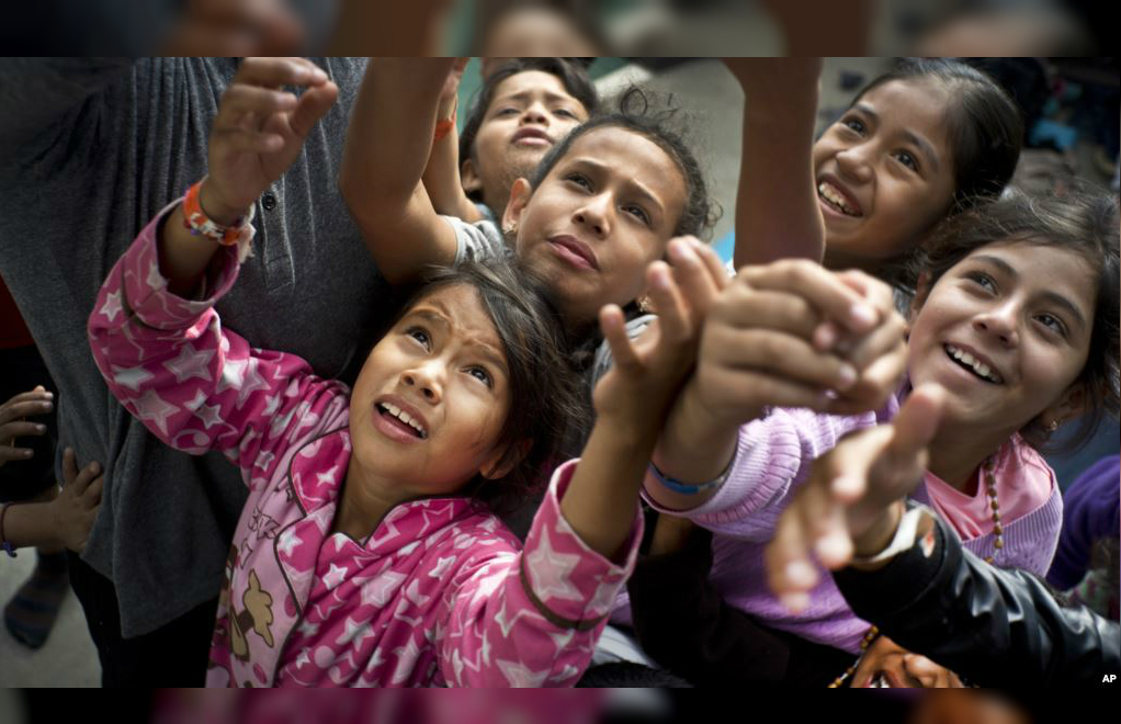 Niños migrantes, que forman parte de las caravanas de centroamericanos que buscan asilo en EE.UU., esperando caramelos que les ofreció un trabajador social en el refugio en Tijuana, el martes 20 de noviembre de 2018.