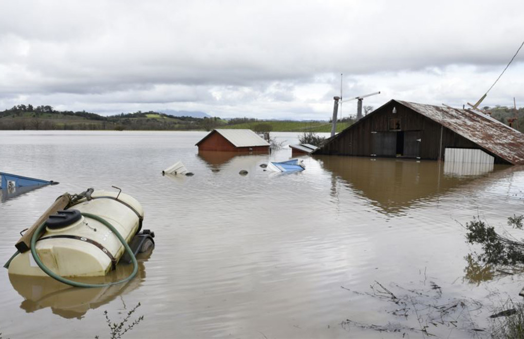 Un granero y equipo agrícola se ven sumergidos en las aguas de la inundación del río Russian en Forestville, California, el miércoles 27 de febrero de 2019. | Foto: Voz de América / AP