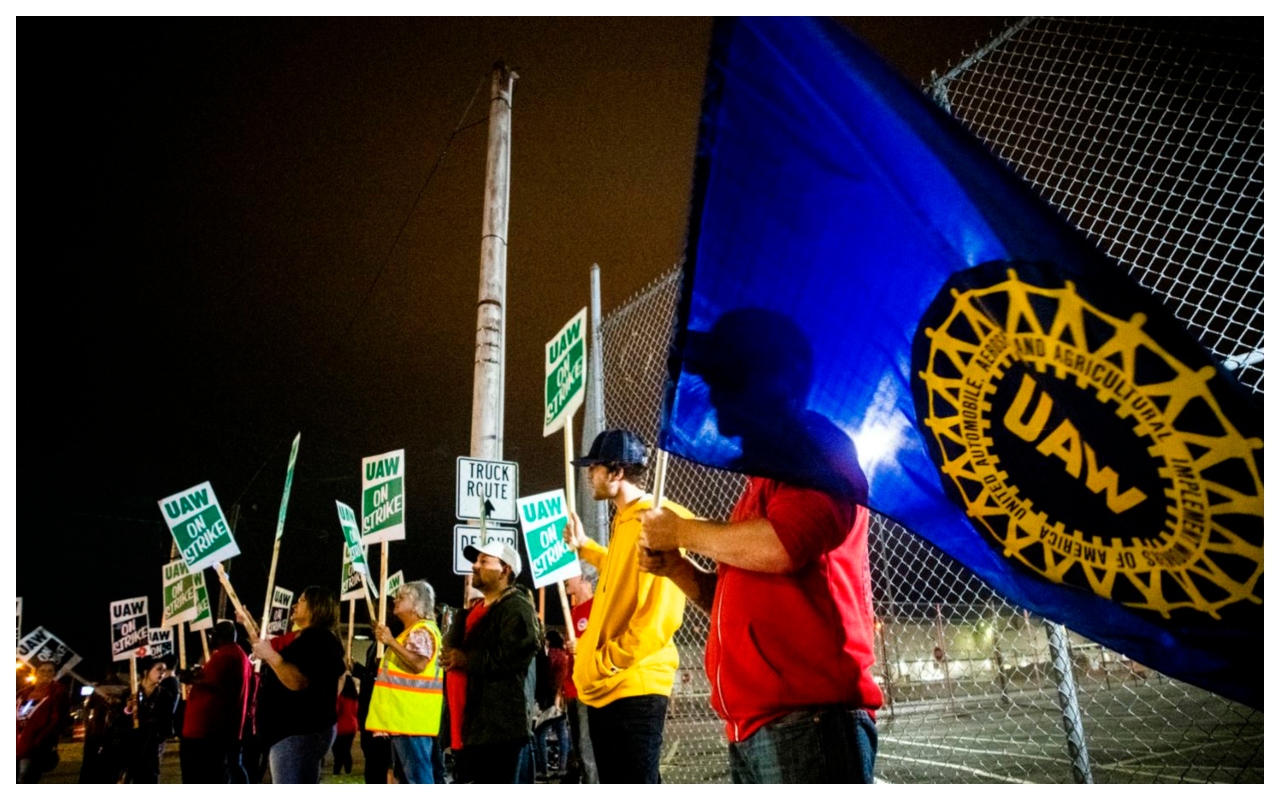 Jeff Elkins, de 37 años, empleado de una fábrica de General Motors, ondea una bandera del sindicato de trabajadores automotrices( United Auto Workers) al final del turno de medianoche de la Planta de Ensamblaje de Flint, Michigan. Sep.16 de 2019. Foto: Jake May/The Flint Journal via AP