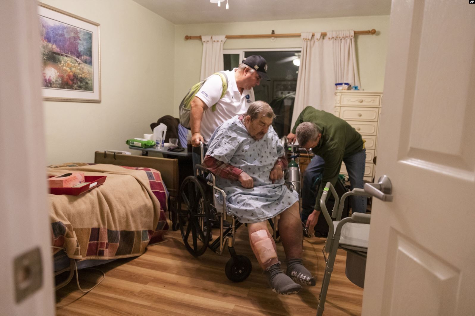 Henry Provencher, de 87 años, es ayudado por su hijo y otra persona para evacuar la residencia de cuidado médico donde es atendido en Santa Rosa. Sábado 26 de octubre de 2019. AP.