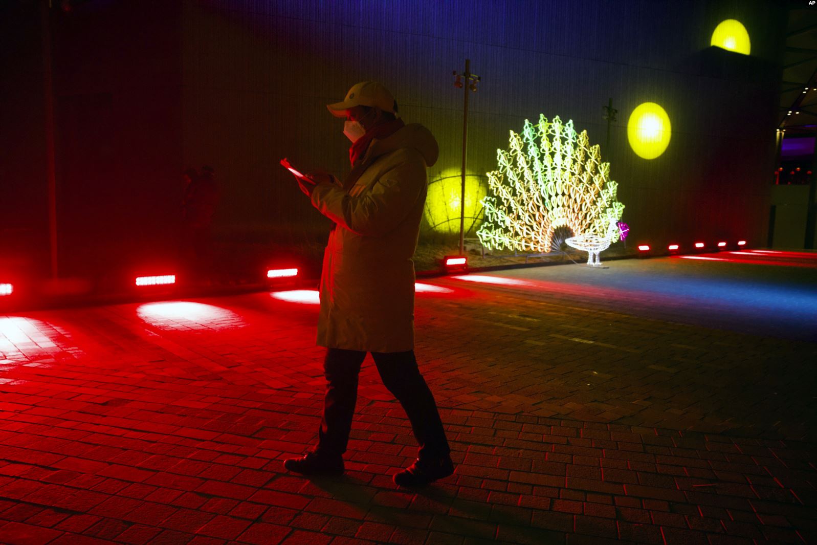 Un hombre camina el 31 de diciembre de 2019 cerca a una escultura de luz antes del conteo de año nuevo en el las instalaciones de los Juegos Olímpicos de Invierno de Bejing (2022). | Foto: AP / Voz de América