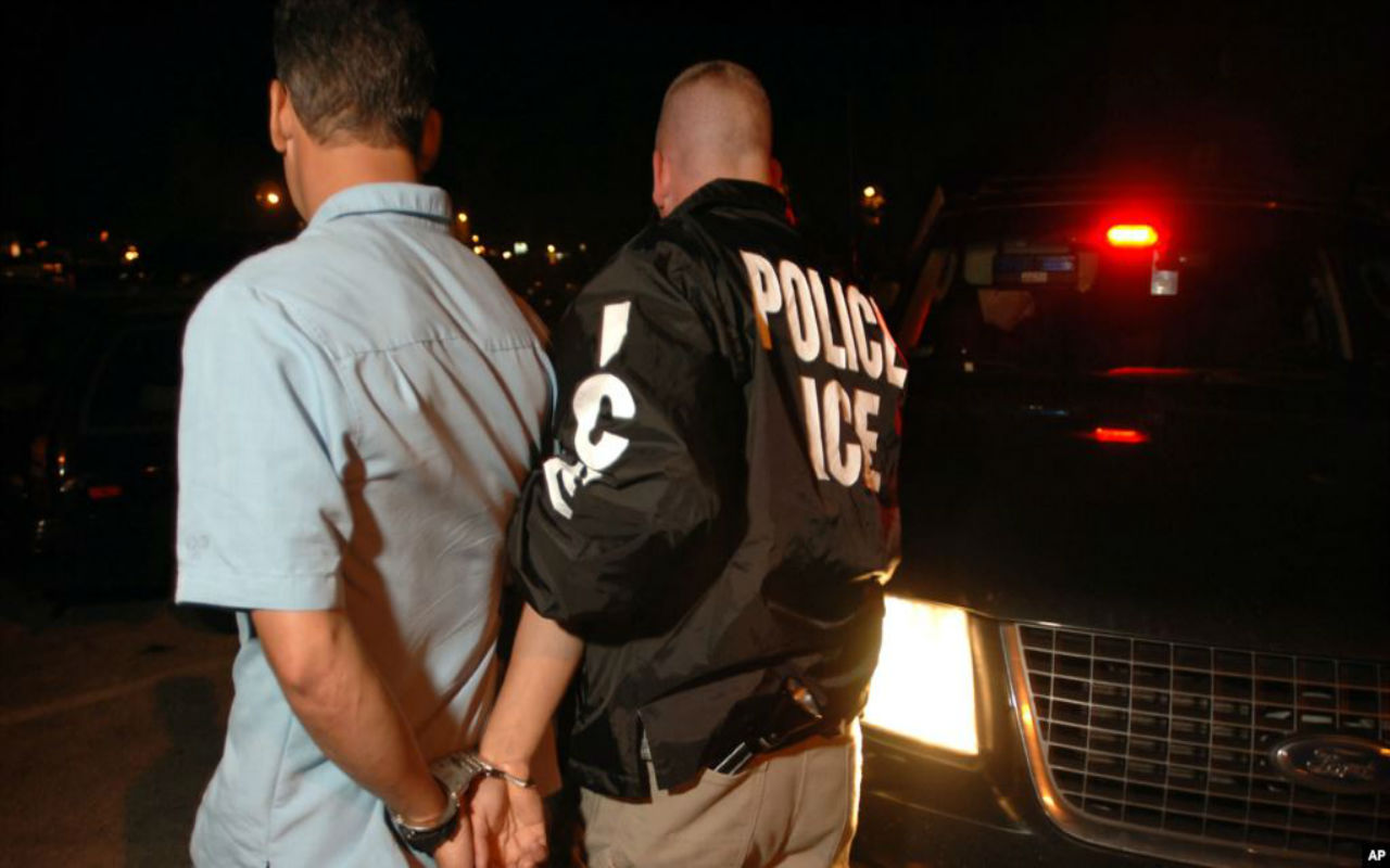 Un agente de la agencia de Inmigración y Control de Aduanas arresta a un hombre recogido en Brockton, Massachusetts.