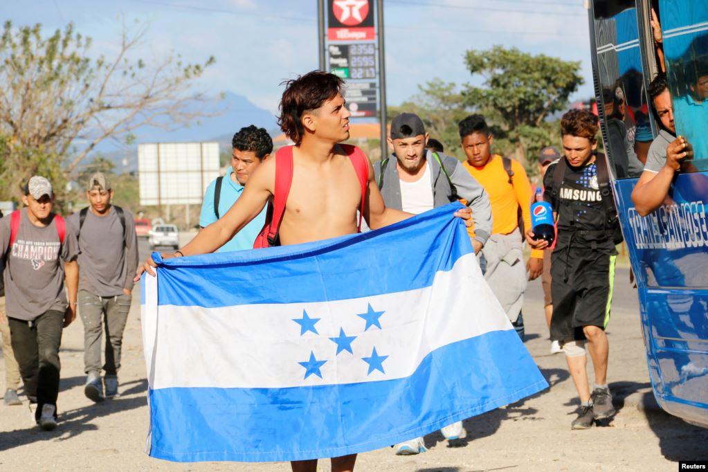 Uno de los integrantes sostiene una bandera nacional hondureña, en su camino hacia Estados Unidos, en Cucuyagua.