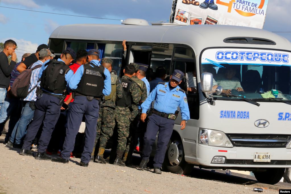 Oficiales militares y policiales verifican documentos de hondureños que participan en una nueva caravana de migrantes hacia los Estados Unidos, en San Marcos.