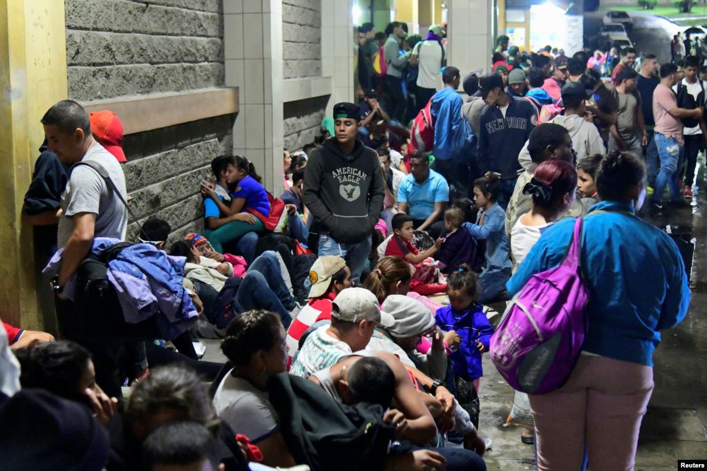Hondureños esperan para partir con una nueva caravana de migrantes que se dirigirá a Estados Unidos, en una estación de autobuses en San Pedro Sula.