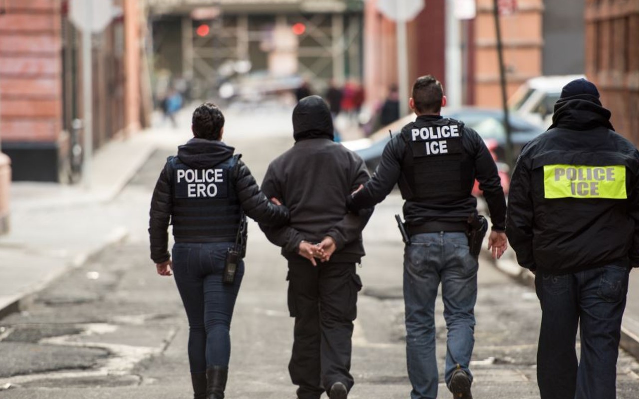 Agentes de ICE deteniendo a un migrante