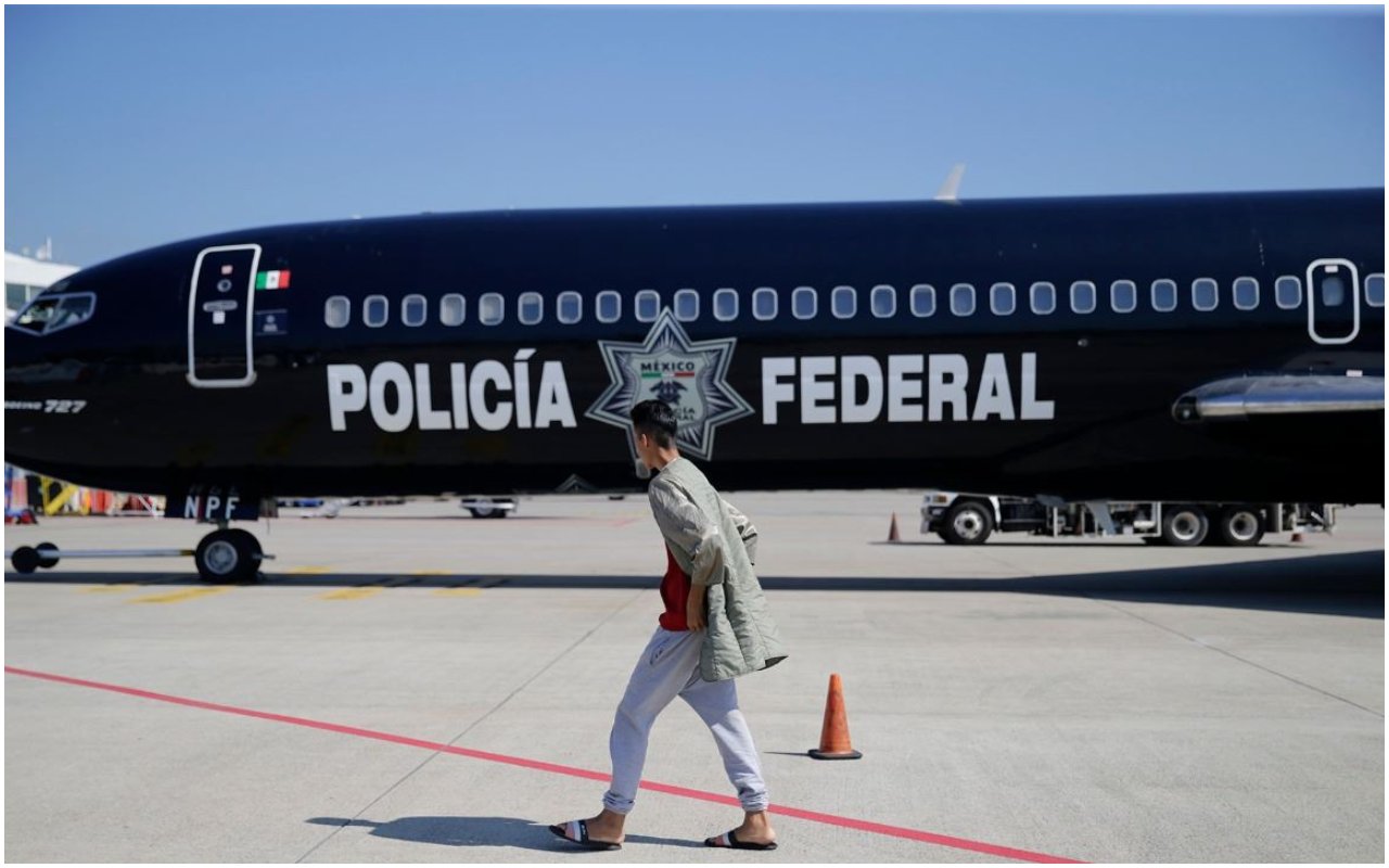 Uno de los migrantes de Honduras deportados camina frente al avión mexicano que lo devolvió a su país.