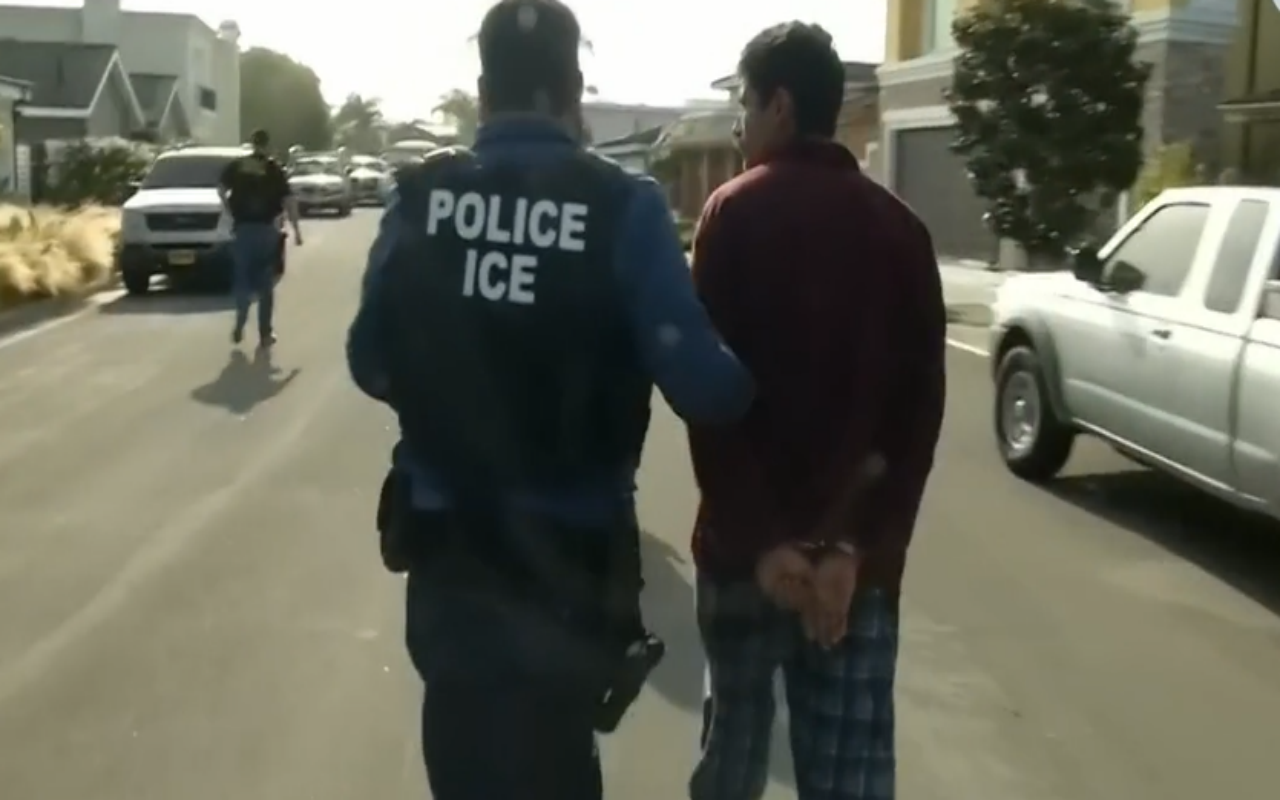 Agente de ICE arrestando a un hombre
