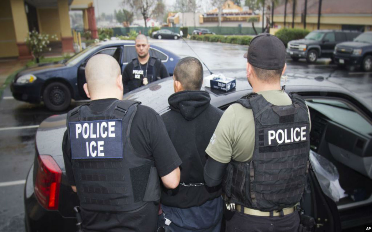 Agentes de ICE deteniendo a migrante