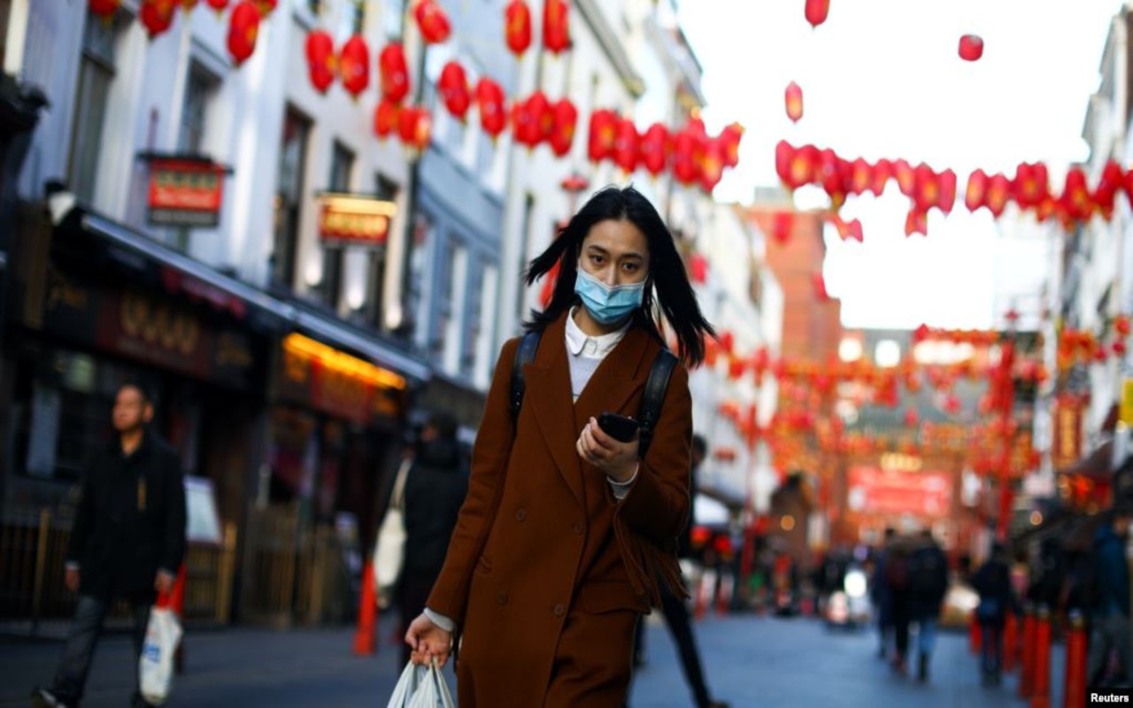 Una mujer usa una máscara protectora camina en el distrito de Chinatown, en Londres, Gran Bretaña, el 2 de marzo de 2020.