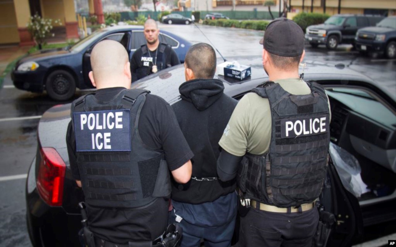 Agentes de ICE arrestando a un migrante