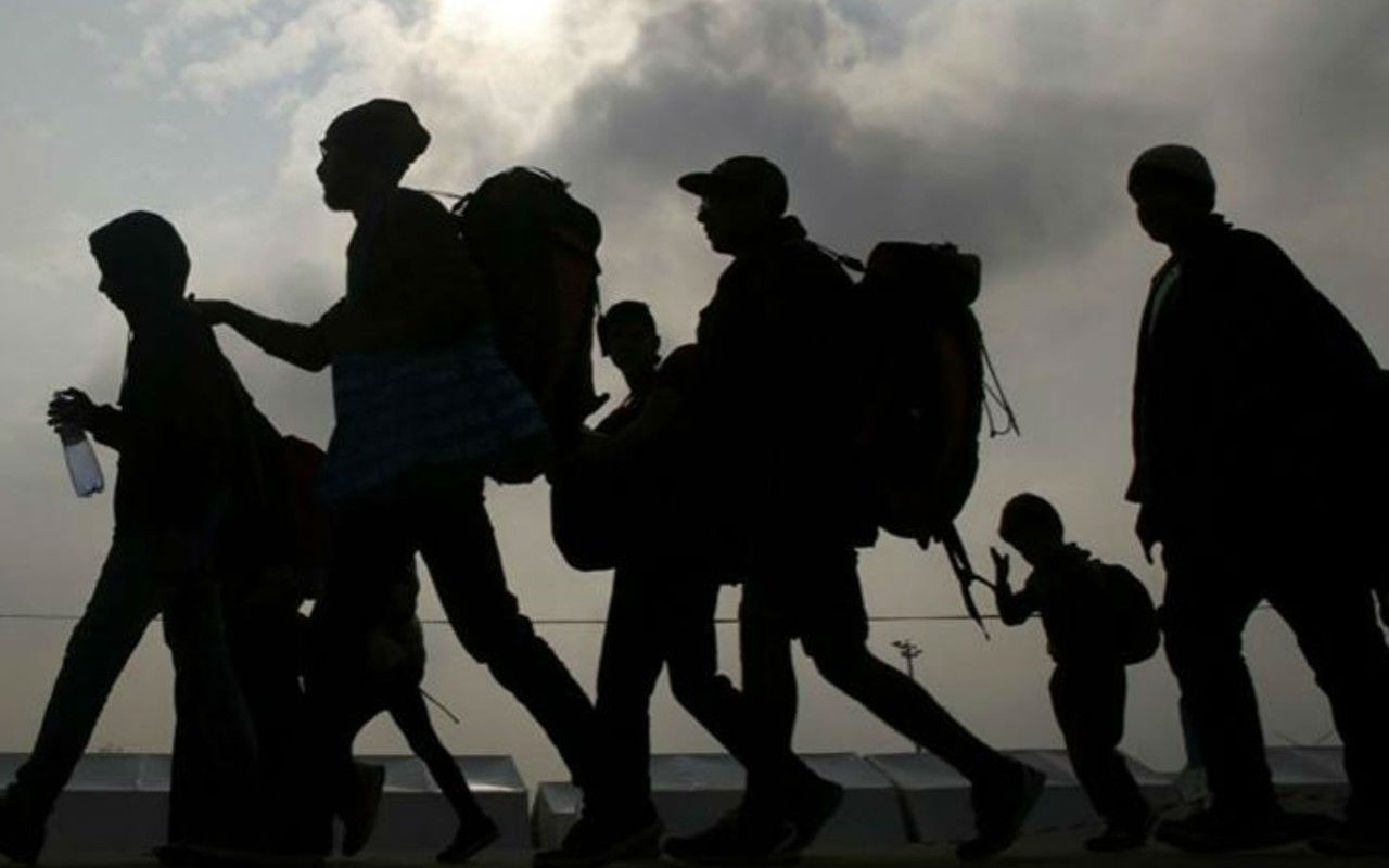 Migrantes caminando a contraluz