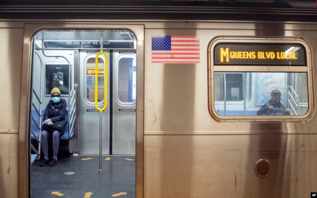 Pasajeros con mascarilla en tren de NY