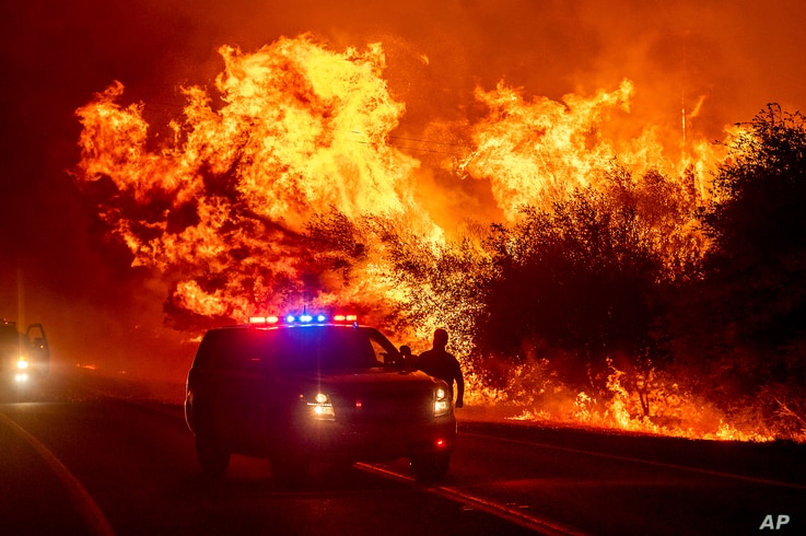 Las llamas se ven por encima de vehículos en la autopista 162 mientras el Bear Fire arde en Oroville, California, el miércoles 9 de septiembre de 2020. Foto: AP, VOA.