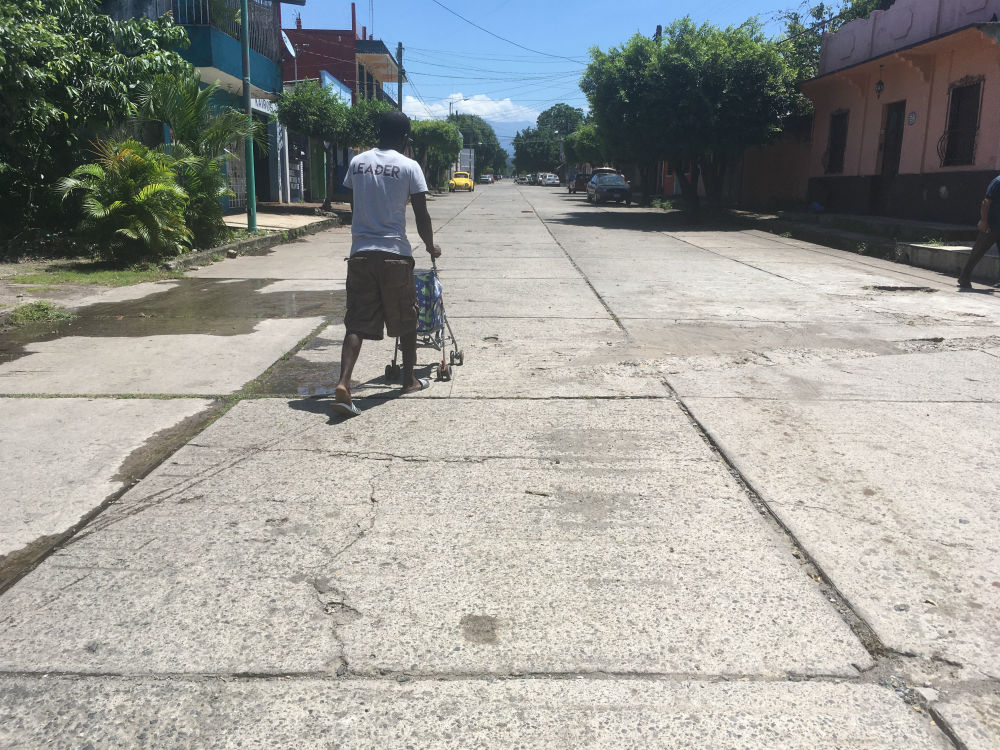 Sergoi pasea a su hija, "La Nena", en una carriola por las calles de Tapachula, tras buscar un punto con señal abierta de wifi. | Foto: Javier García.