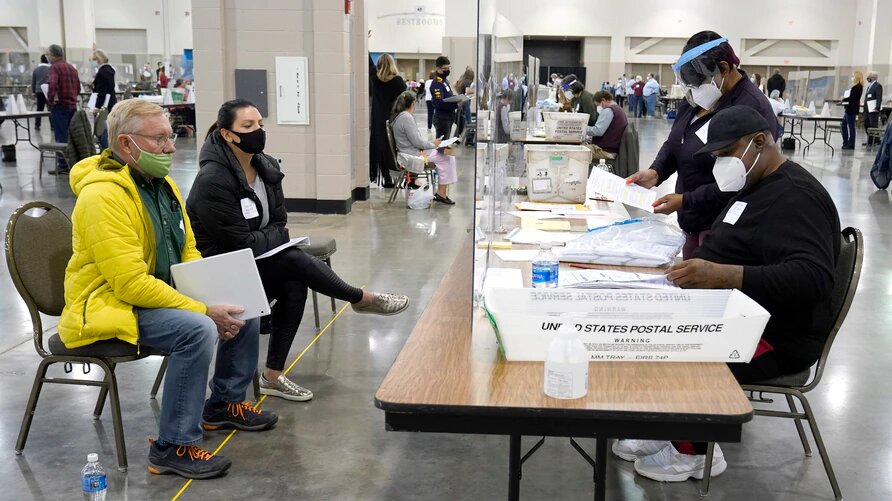 Trabajadores electorales verifican votos bajo la mirada de observadores durante el recuento en el Centro Wisconsin, en Milwaukee, el viernes 20 de noviembre de 2020. Este recuento verificó la victoria de Biden. | Foto: VOA.
