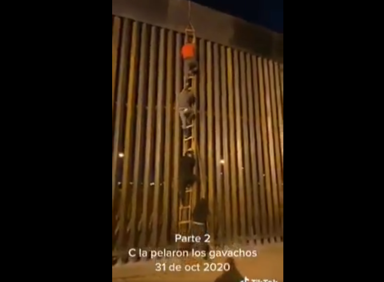 Toma del momento en el que los hombres saltan el muro fronterizo. | Foto: Captura de video.