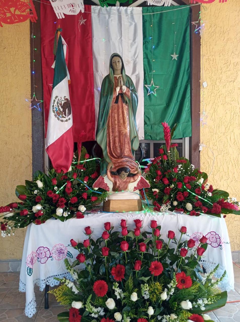 Altar con la bandera y Virgen llena de rosas