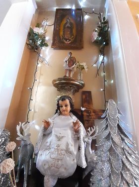 Altar de la Virgen de Guadalupe con un niño Dios vestido de blanco