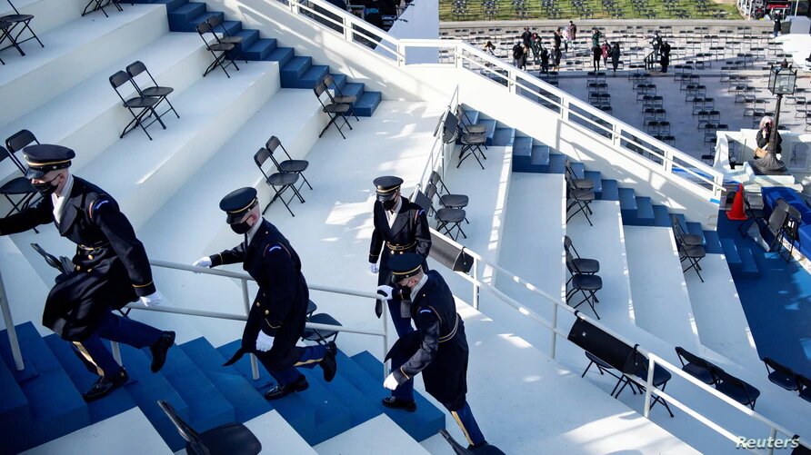 Miembros de la Guardia de Honor evacúan la gradas de la ceremonia de investidura de Biden durante un ensayo, después que se reportara una amenaza de seguridad externa en el Capitolio en Washington, D.C., el lunes 18 de enero de 2021. | Foto: VOA.
