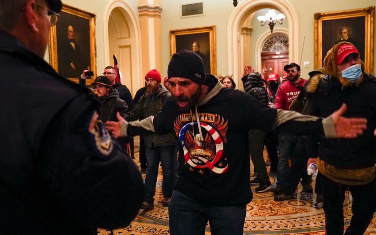 Un seguidor de QAnon se enfrente a los cuerpos de seguridad del Capitolio. | Foto: AP / Voz de América.