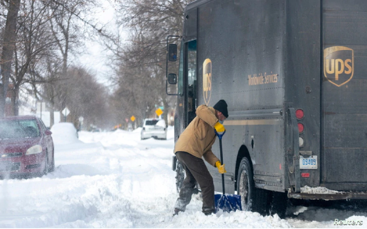 Mike Charnesky ayuda a un camión de reparto de UPS que está atascado en Detroit, Michigan, Estados Unidos, 16 de febrero de 2021. | Foto: Reuters / VOA.