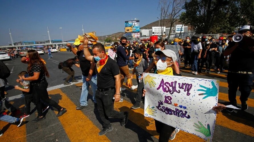 Inmigrantes protestan contra las políticas inmigratorias de Estados Unidos y México. También por el derecho a pedir asilo político. Foto en el puesto fronterizo de Tijuana. | Foto: VOA.