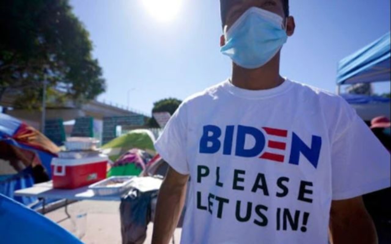 Un hombre de Honduras en busca de asilo en los Estados Unidos lleva una camisa que dice: "Biden favor déjanos entrar", el 1 de marzo, en Tijuana, México. | Foto: AP / Voz de América