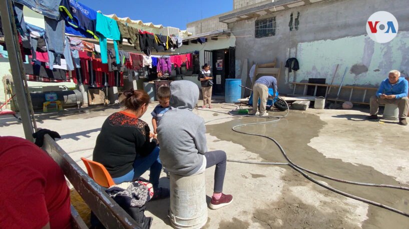 Inmigrantes aguardan sentados en el patio del refugio El Buen Samaritano, en Ciudad Juárez, México, su hogar durante la larga espera.