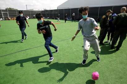 Niños migrantes juegan fútbol en un pequeño campo en el Centro de Detención del Departamento de Seguridad Nacional en Donna, Texas, el principal lugar de detención de niños no acompañados. | Foto: AP / VOA.