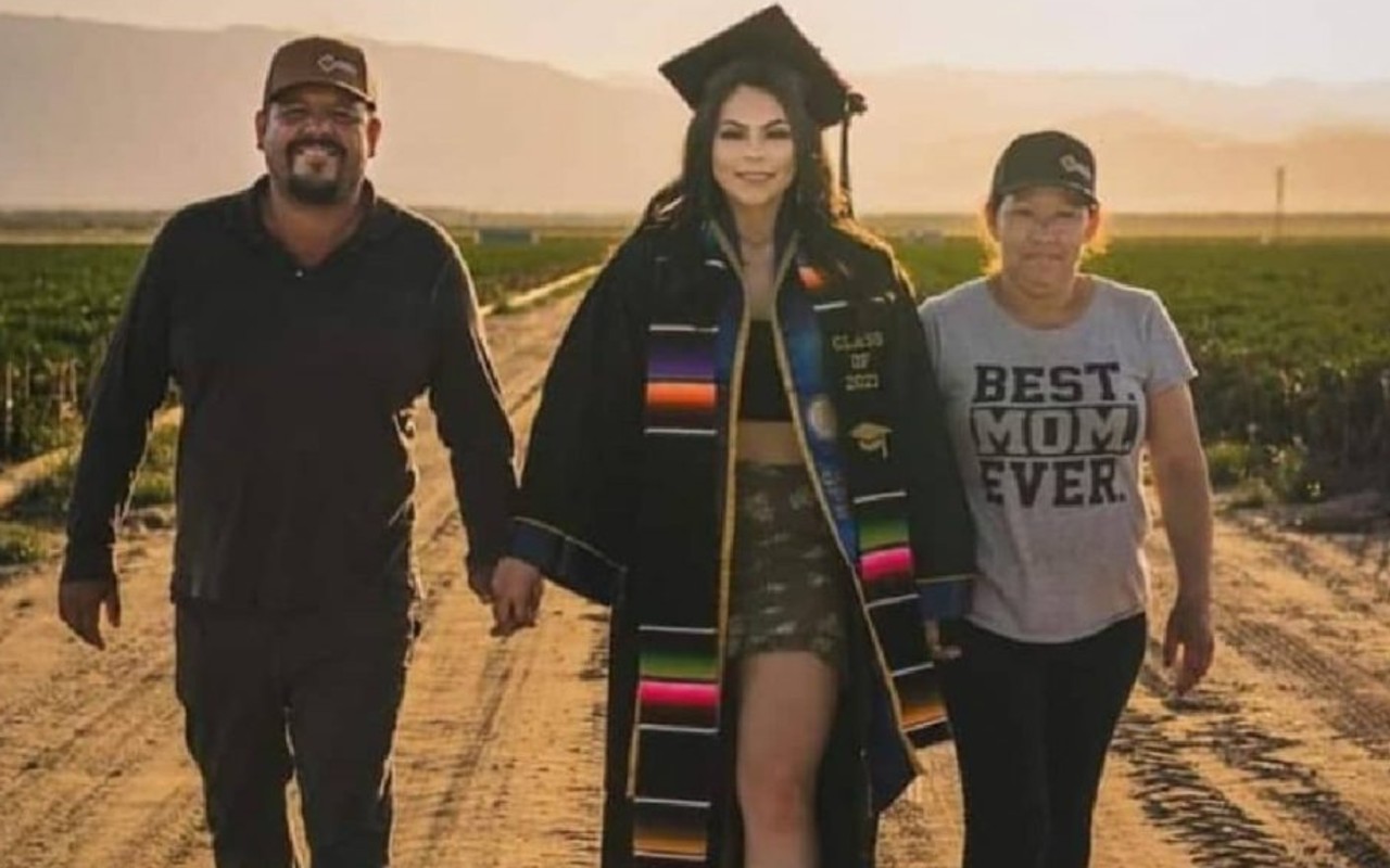 Universitaria graduada se toma fotos con sus padres migrantes en el campo