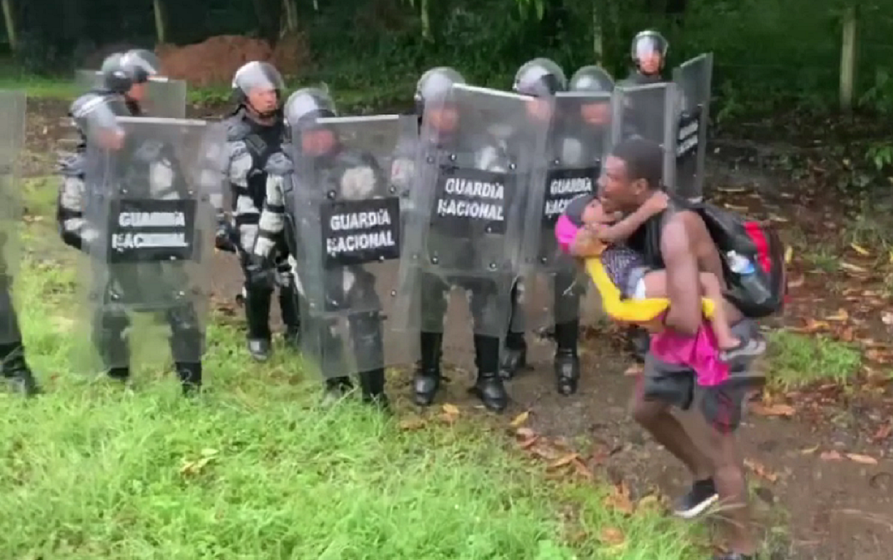 Miembros de la Guardia Nacional encapsulando a un hombre que viajaba con su hijo en la caravana migrante. | Foto: Video del COMDHSM.