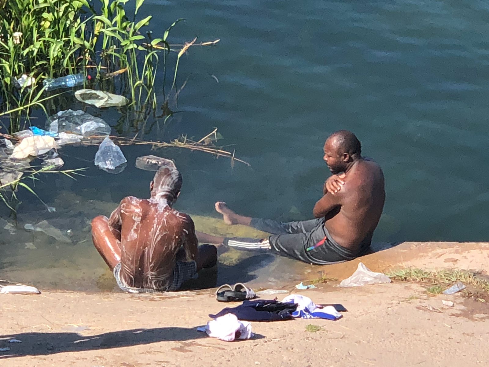 Algunos migrantes toman un descanso en su camino para bañarse a las orillas del Rio Bravo. | Foto: Cortesía de Guillermo Flores.