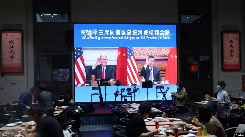 Un restaurante en China transmite la reunión virtual de Joe Biden y Xi Jinping el 15 de noviembre de 2021. | Foto: VOA/Reuters.