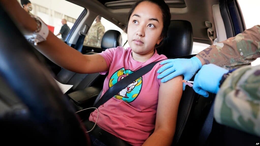 Una joven recibe su segunda dosis de la vacuna Pfizer contra el Covid-19 en la unidad de Servicios Humanos y de Salud del Condado de Dallas en Mesquite, Texas. | Foto: VOA/AP.