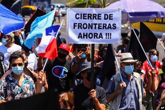 Una de las pancartas de los manifestantes exige el cierre de fronteras. | Foto: VOA/AP.