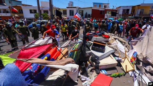 Manifestantes destrozan tiendas de los migrantes cerca de la playa. | Foto: VOA/AP.