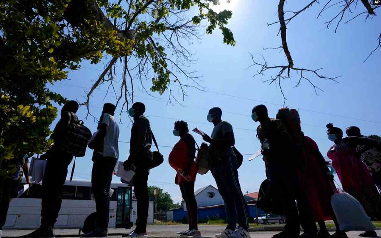 Migrantes hacen fila en un centro de descanso después de que cruzaron la frontera entre Estados Unidos y México | Foto: Voz de América / AP