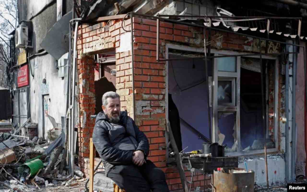 Un residente local está sentado fuera de un edificio dañado durante la guerra Rusia-Ucrania en la ciudad portuaria sitiada del sur de Mariúpol, Ucrania, 31 de marzo de 2022. | Foto: VOA / Reuters / Alexander Ermochenko.