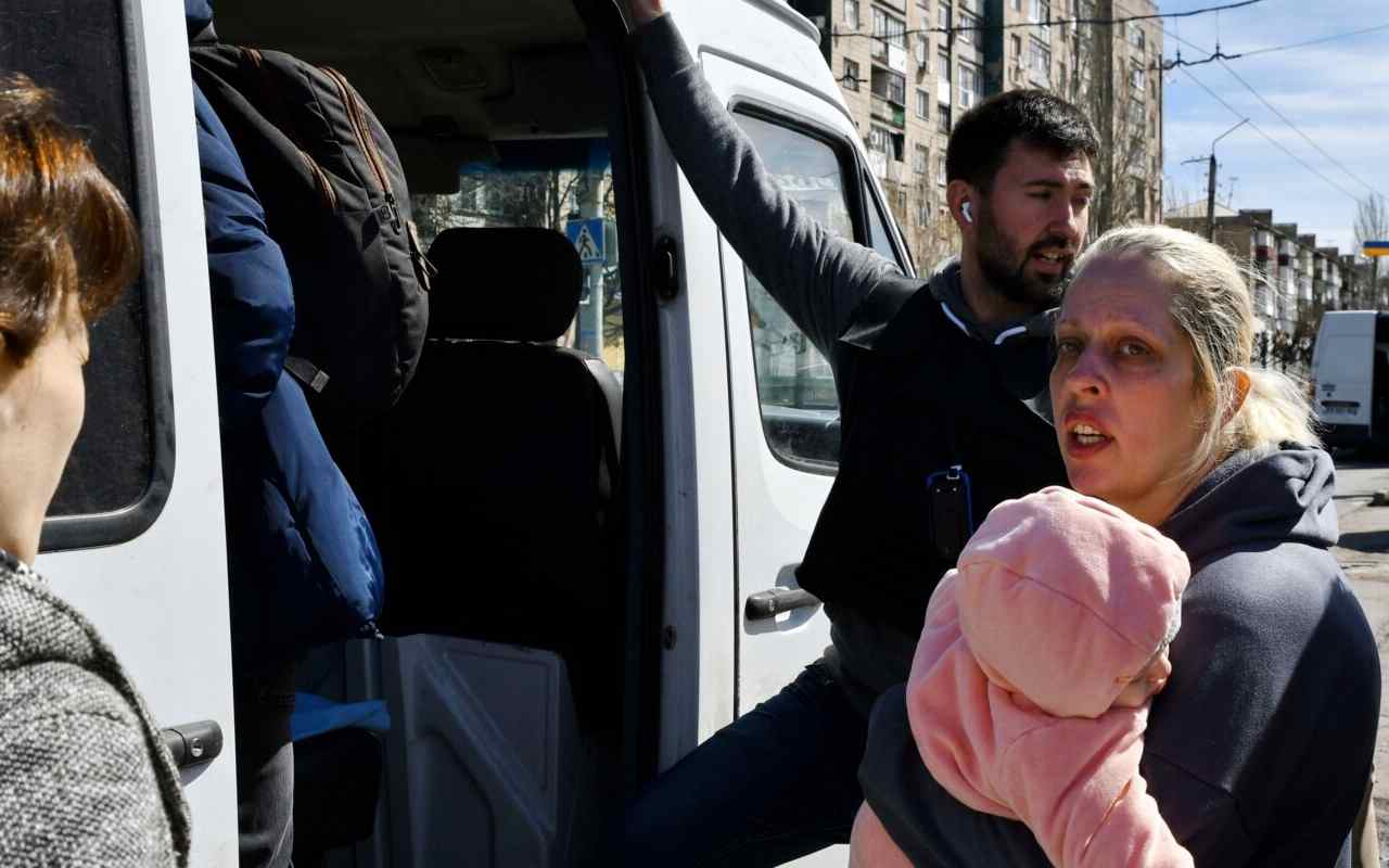 Una mujer con un niño sube a un autobús mientras evacuan a los civiles por la guerra en Ucrania,| Foto: AP / Voz de América