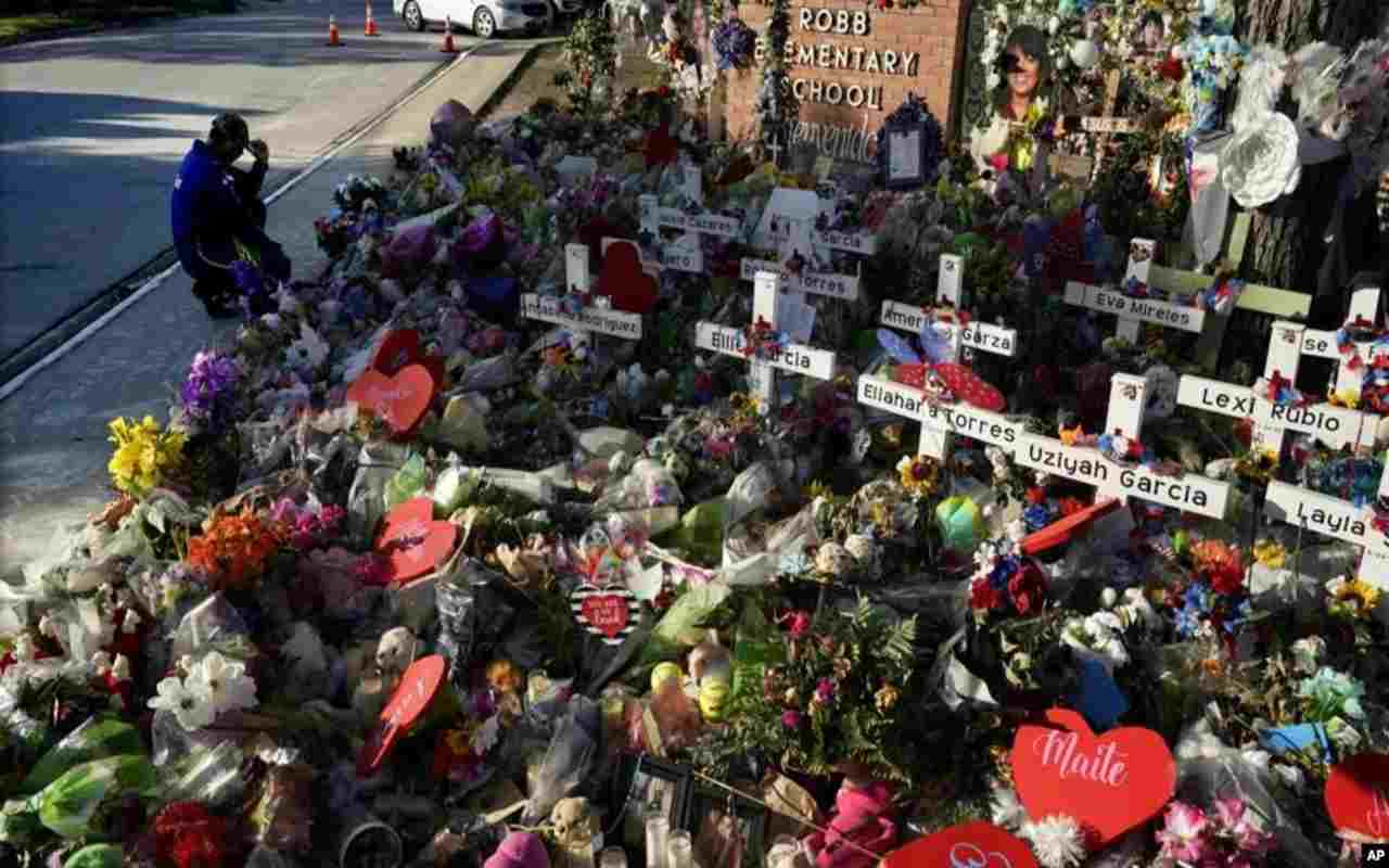 Un hombre se arrodilla el 2 de junio de 2022 frente a un sitio en memoria de las víctimas de un tiroteo en la escuela primaria Robb ocurrido el 24 de mayo, en Uvalde, Texas. Ahora los familiares presentarán una demanda colectiva. | Foto: VOA / AP / Eric Gay, Archivo.