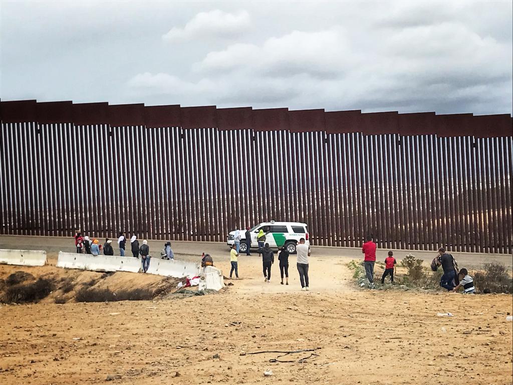Cruzan muro para pedir asilo