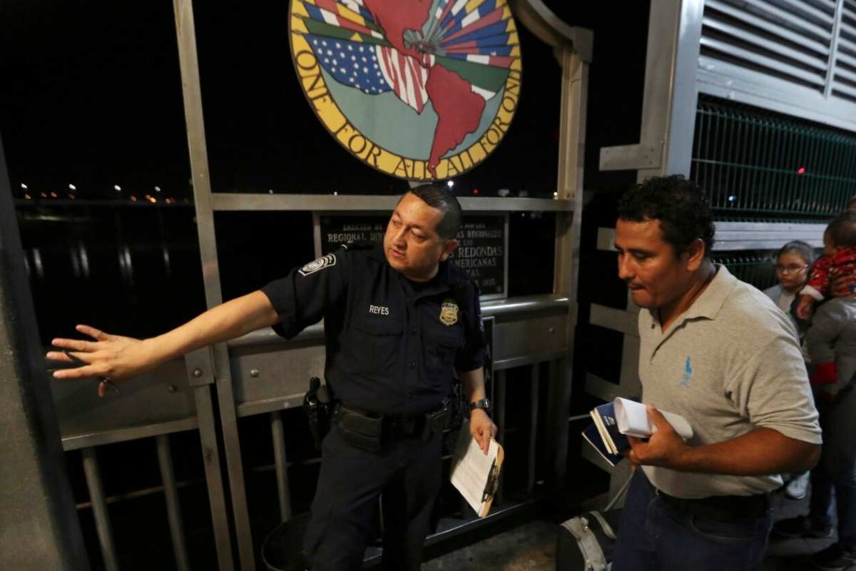 Un agente fronterizo estadounidense le da indicaciones a una familia de migrantes | Foto: AP / Voz de América