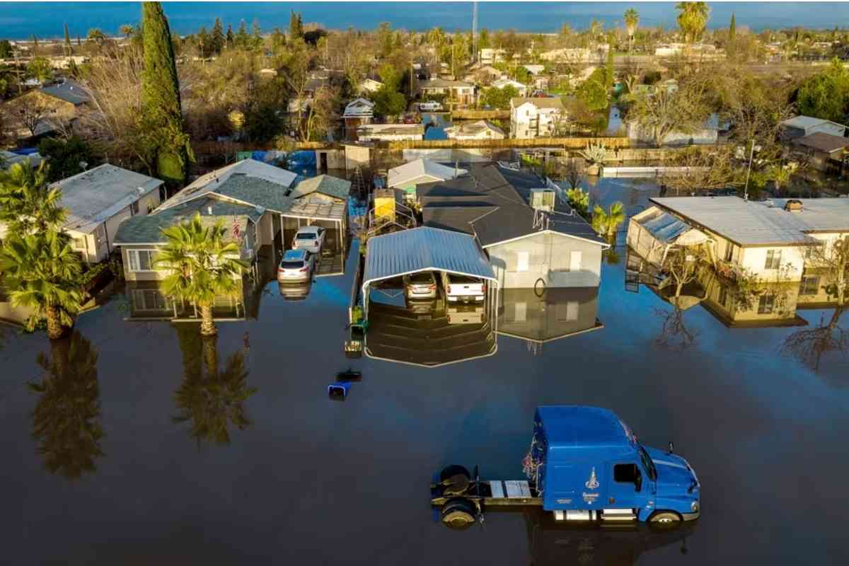 Casas y vehículos rodeados de una inundación tras varios días de lluvias en la población Planada del condado Merced, California | Foto: AP / Voz de América