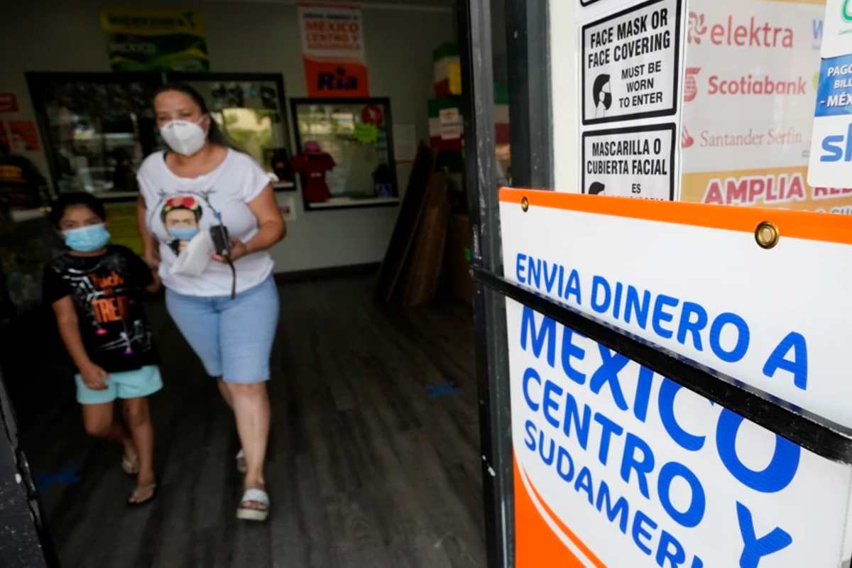Una mujer sale de una tienda que ofrece servicios para enviar remesas a México y Centroamérica, en San Diego | Foto: AP Voz de América